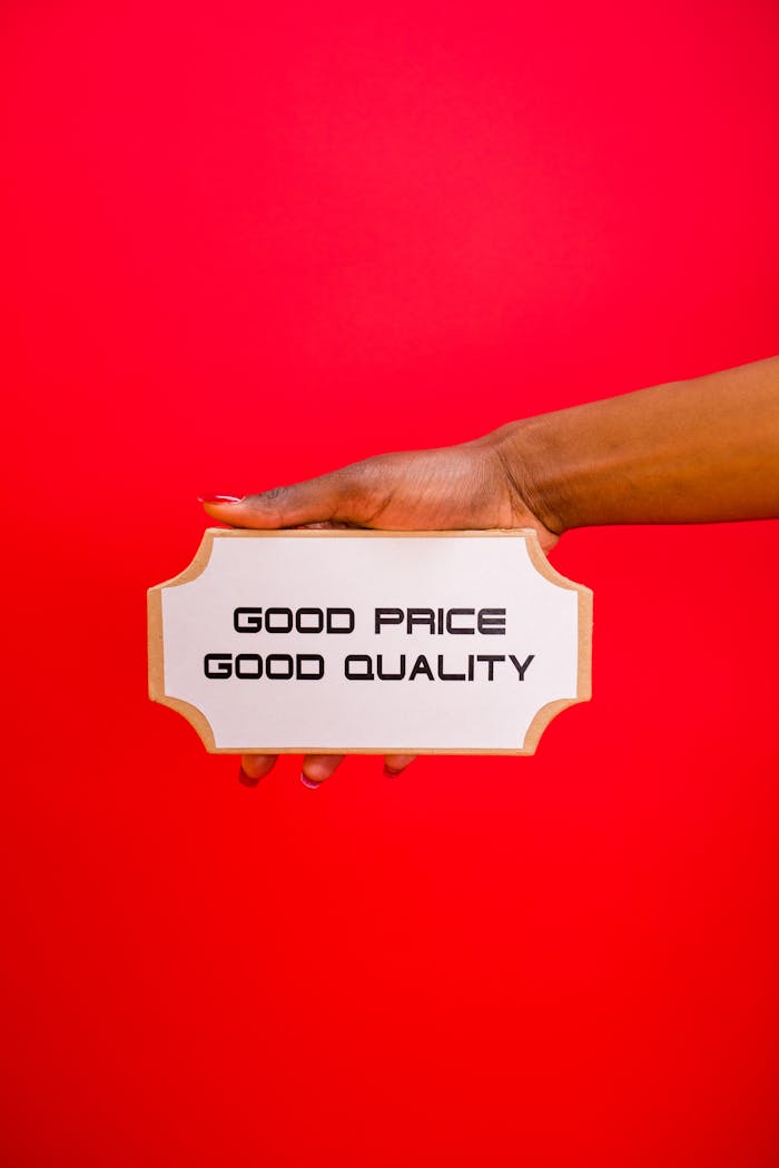 about-02 A hand holding a sign with Good Price, Good Quality text against a bright red background.